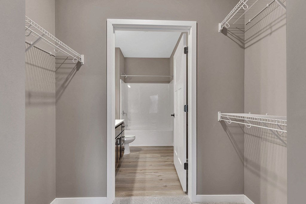 A white doorway leads to a bathroom with a toilet and sink.