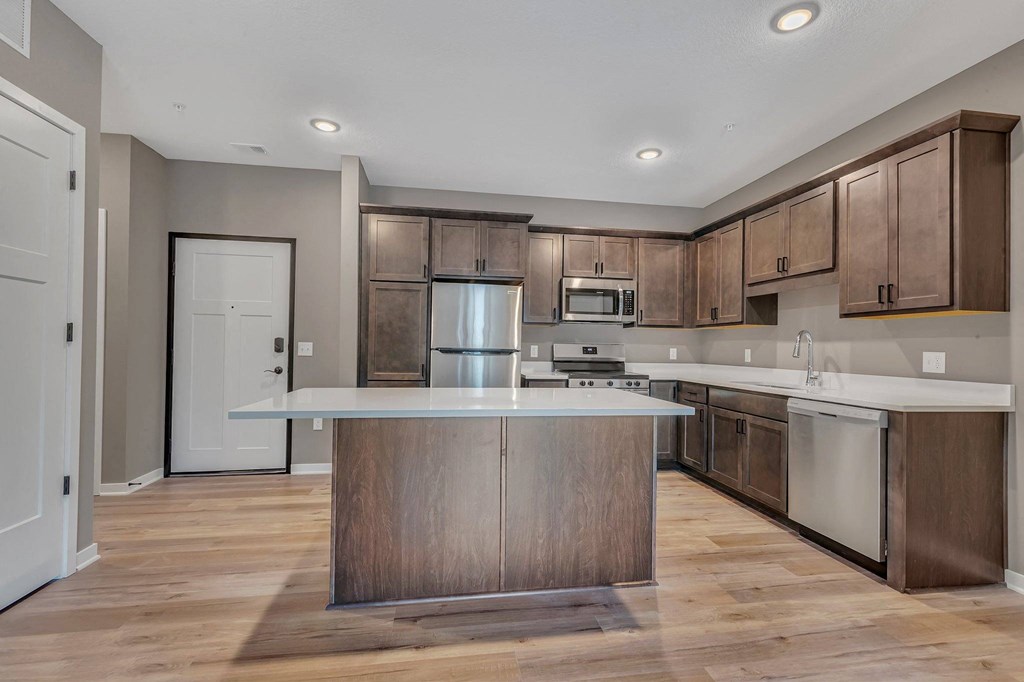 A modern kitchen with wooden cabinets and a central island.