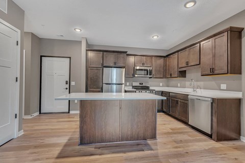 A modern kitchen with wooden cabinets and a central island.