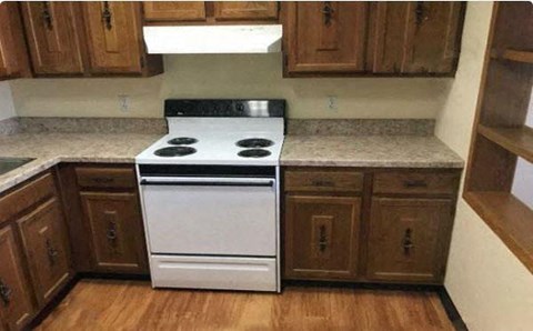a white stove in a kitchen with wooden cabinets