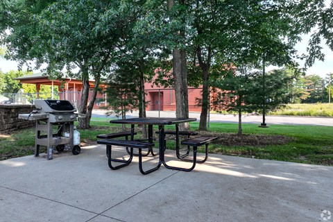a picnic table with a grill in a park