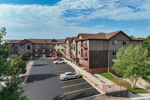 an aerial view of an apartment complex with cars in a parking lot