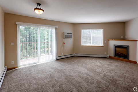 an empty living room with a fireplace and a window
