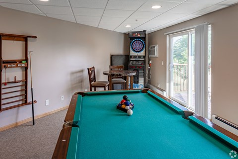 a game room with a pool table and a child playing on a