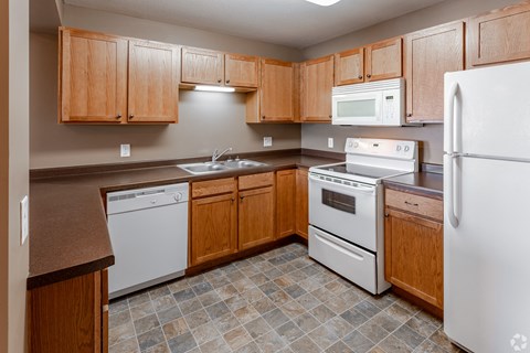 a kitchen with white appliances and wooden cabinets