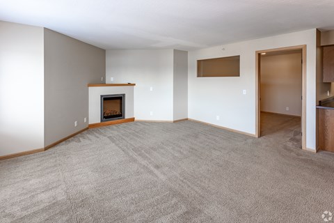 a living room with a fireplace and a carpeted floor