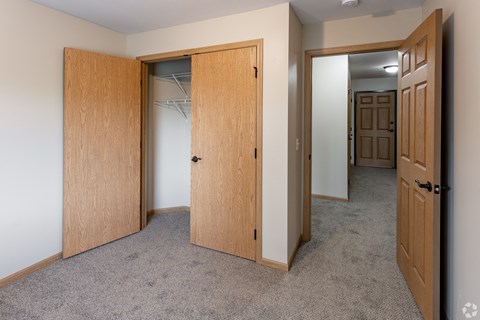 a bedroom with a closet and a door to a bathroom