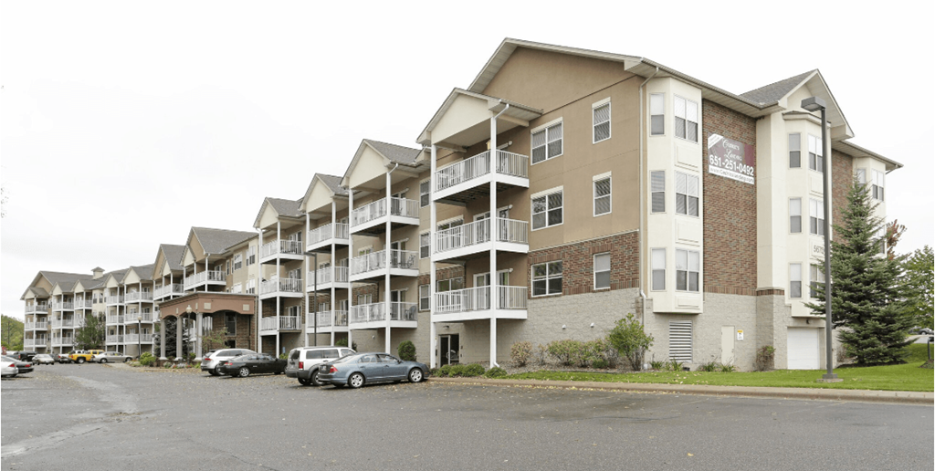 a picture of an apartment complex with cars parked in front of it