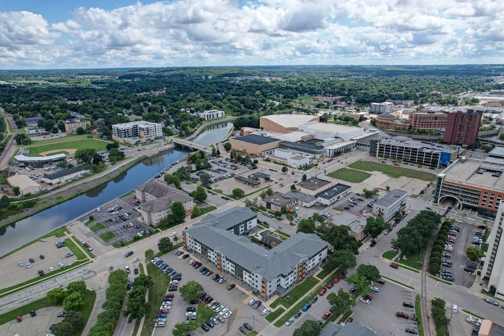 A river flows through a city with a large building in the foreground.