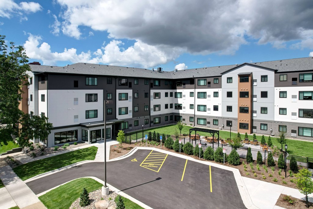 A large building with a parking lot in front.