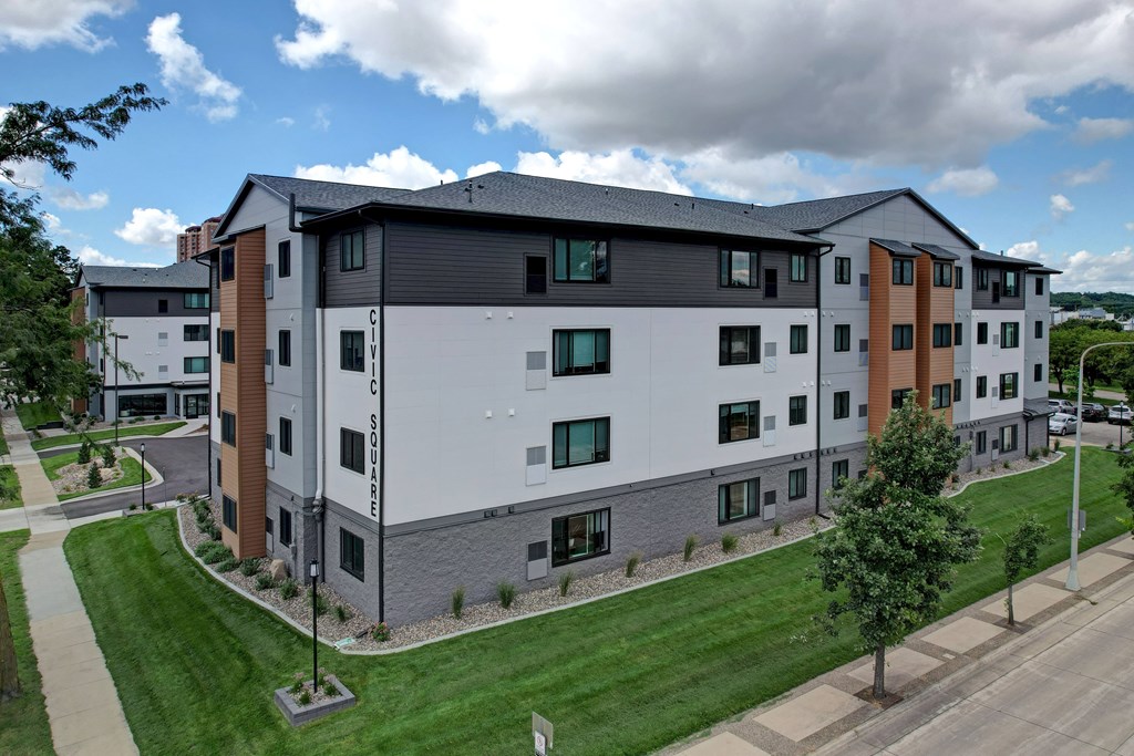 A modern apartment building with a mix of white and brown exterior walls.