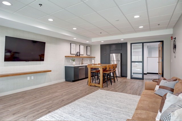 A modern living room with a wooden floor and a grey sofa.