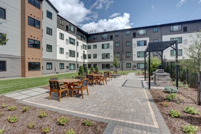 A patio with a table and chairs is surrounded by a brick wall.