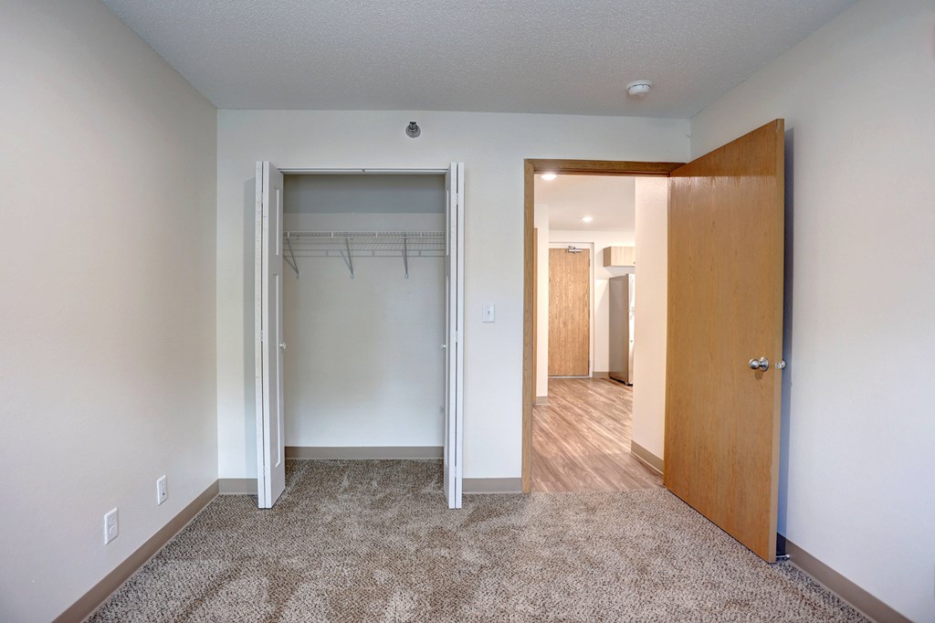 A room with a carpeted floor and a wooden door.
