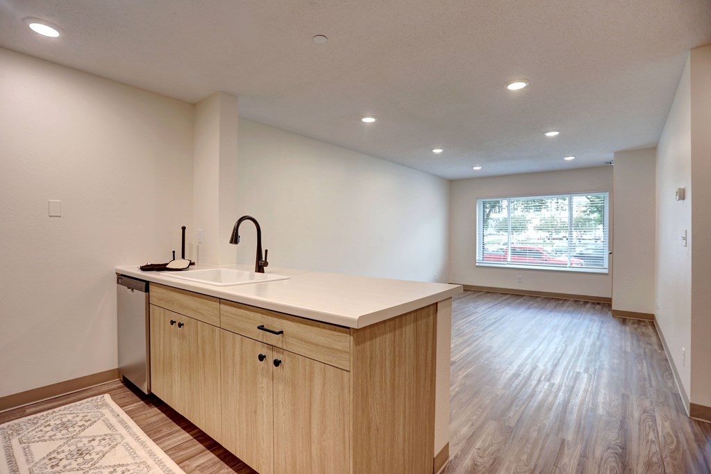 A kitchen with a sink and wooden cabinets.
