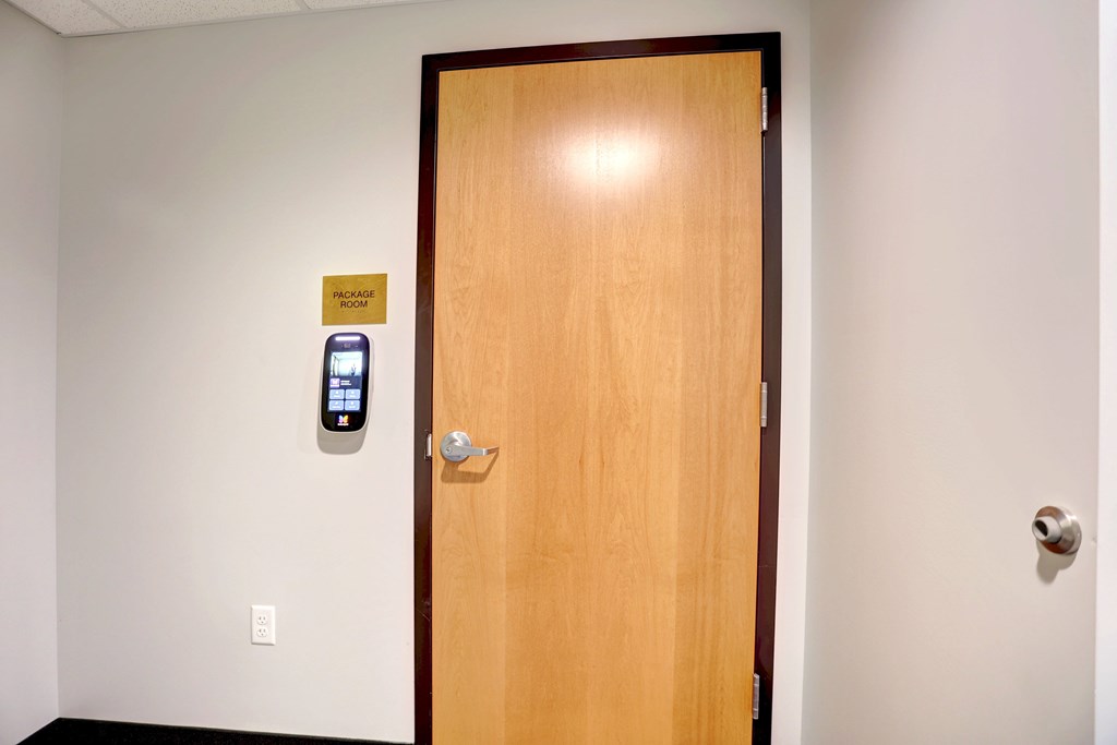 A door with a card reader on the wall.