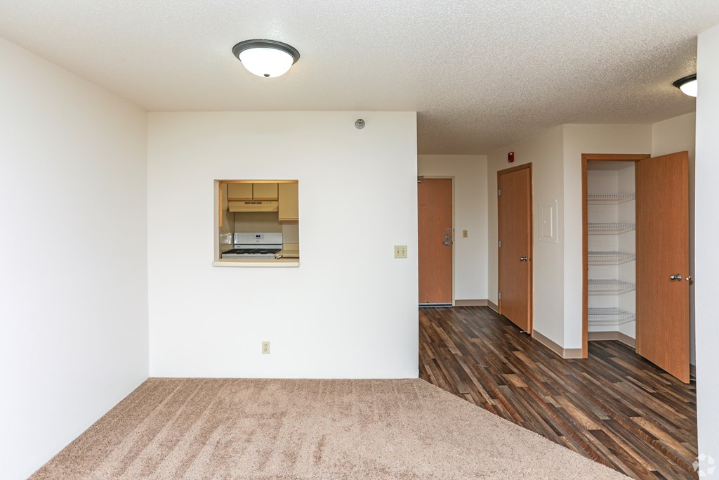 A room with a brown carpet and wooden floors.