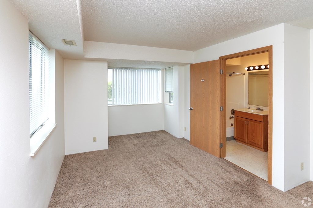 A room with a carpeted floor and a wooden door.
