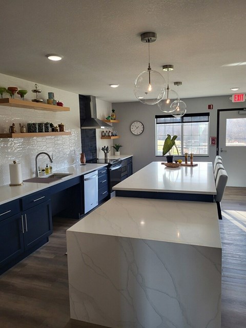 A kitchen with a white counter top and dark cabinets.