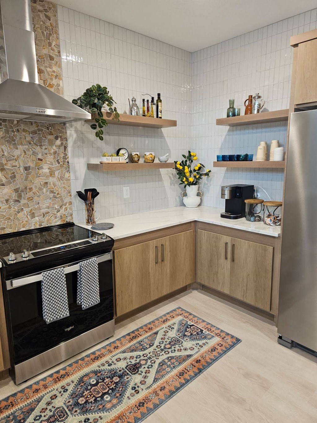 A kitchen with a stone backsplash and wooden cabinets.
