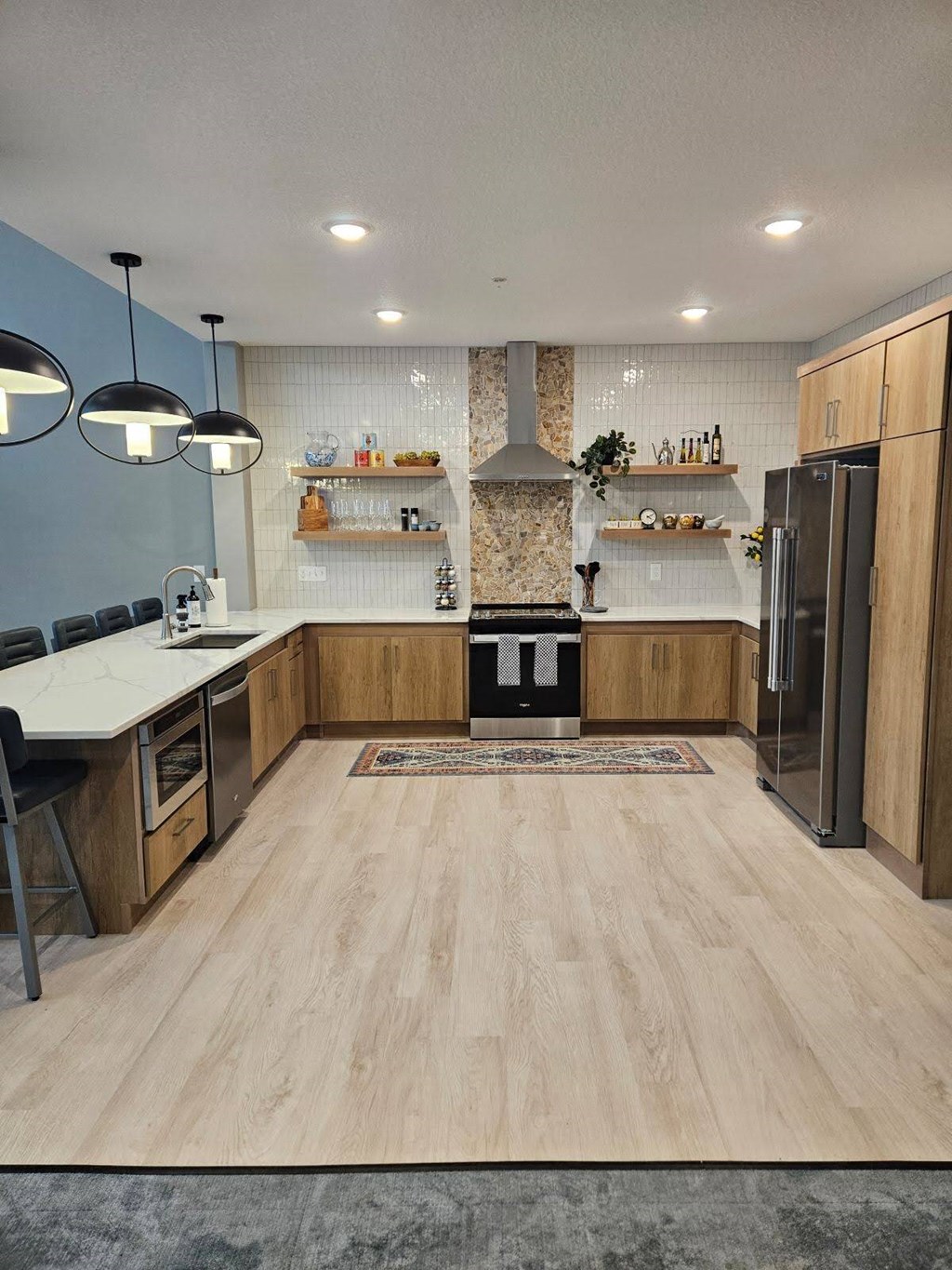 A modern kitchen with wooden floors and a central island.
