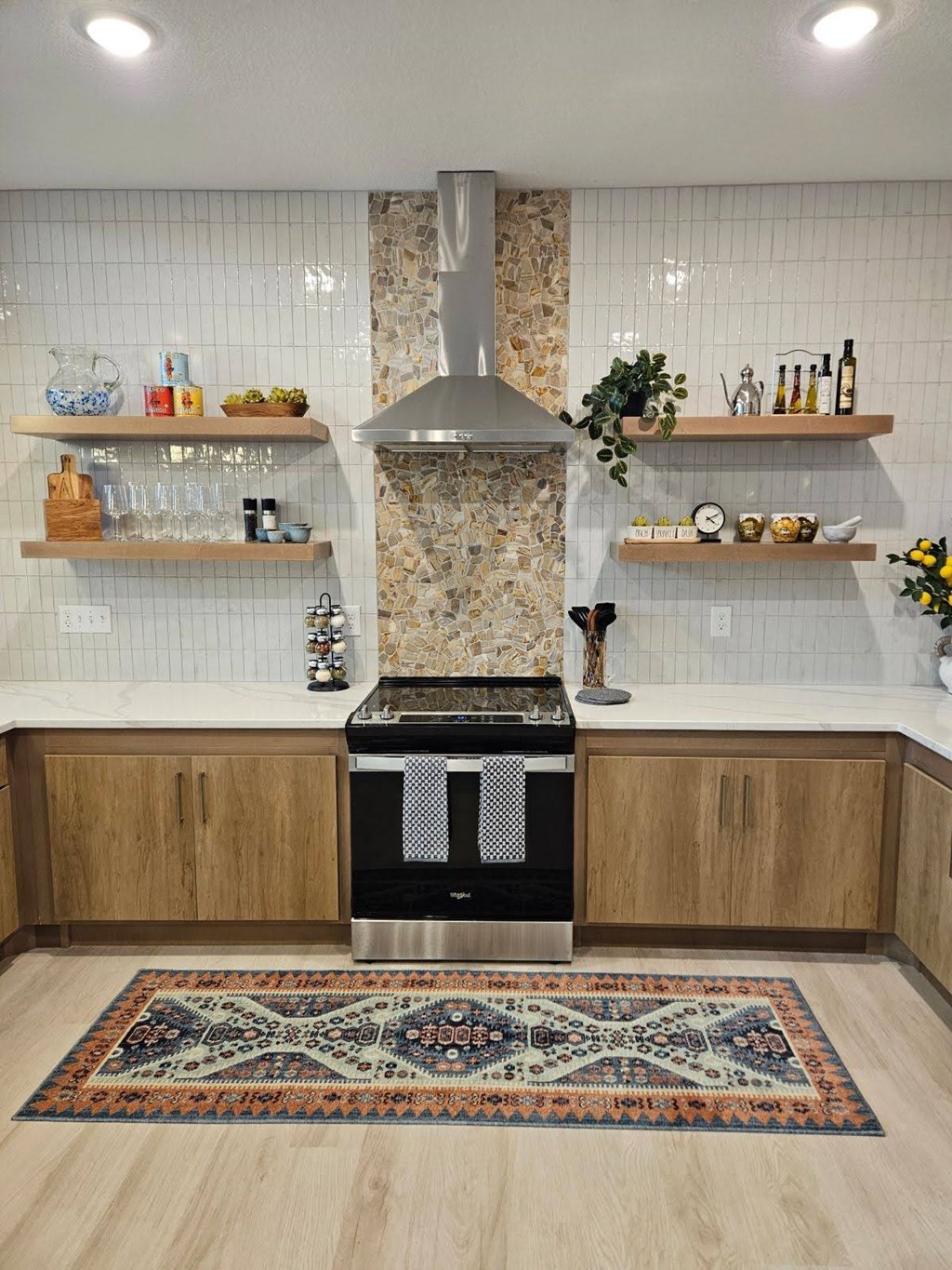 A kitchen with a patterned rug on the floor.