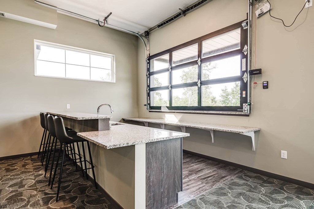 Community room with a bar height counter top and seating plus a window
