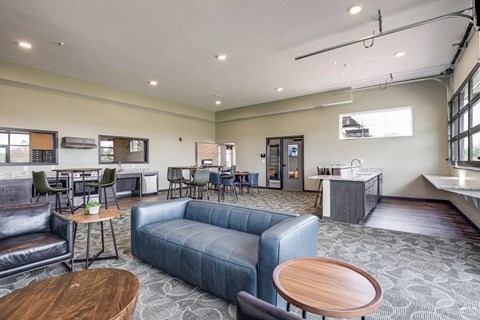 a living room with a couch and tables and a kitchen