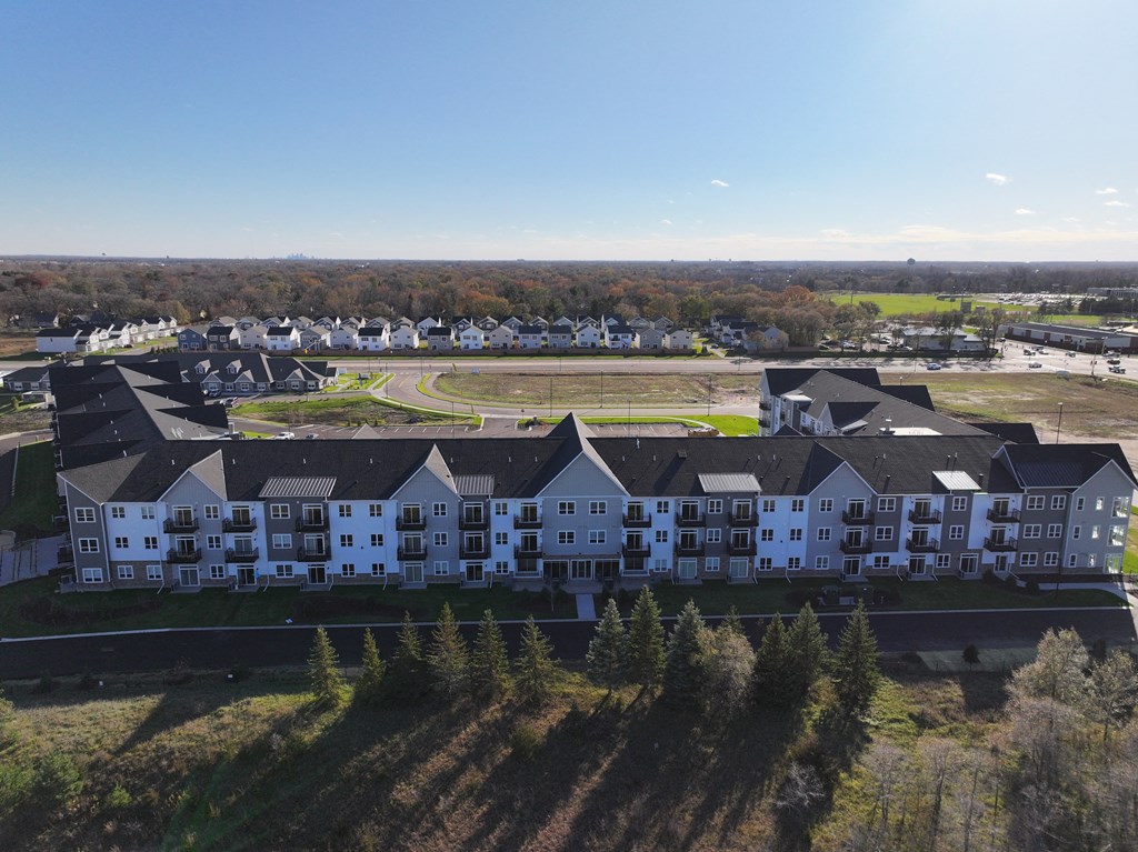 an aerial view of an apartment complex with a field in the background