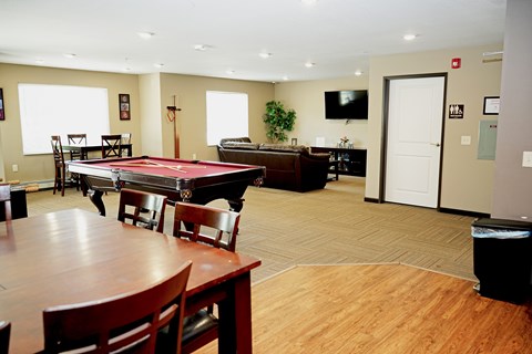 A room with a pool table and a tv.
