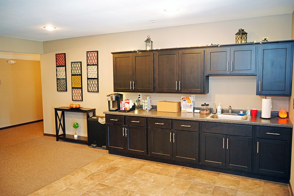 A kitchen with black cabinets and a tiled floor.