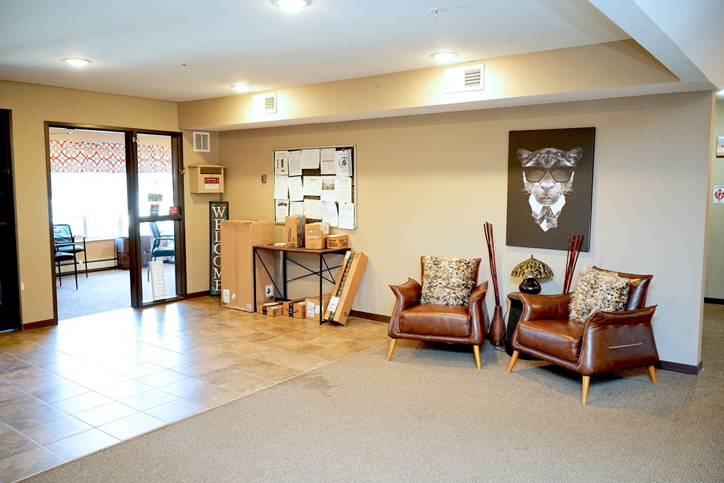 A room with two chairs and a table with boxes on it.