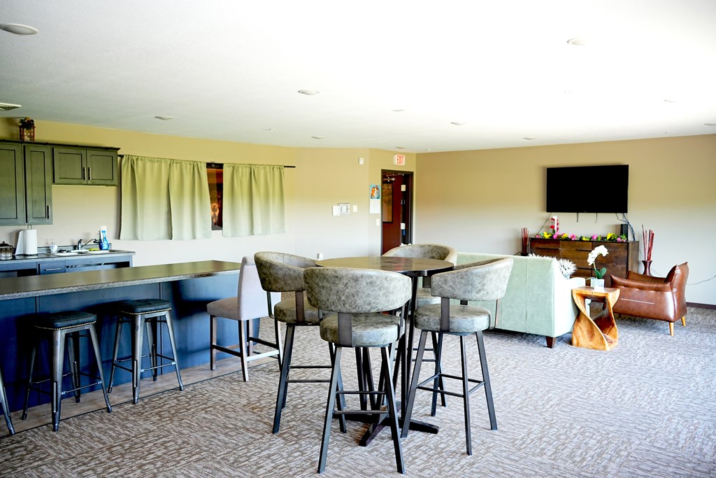 A kitchen with a dining table and chairs.