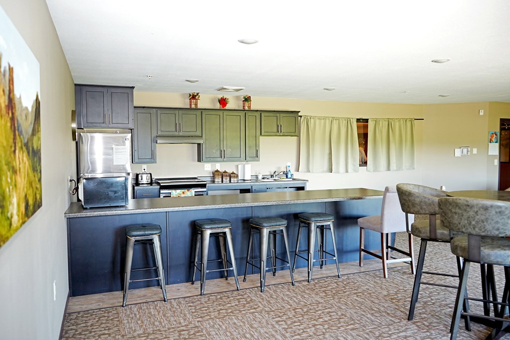 A kitchen with a blue counter and bar stools.