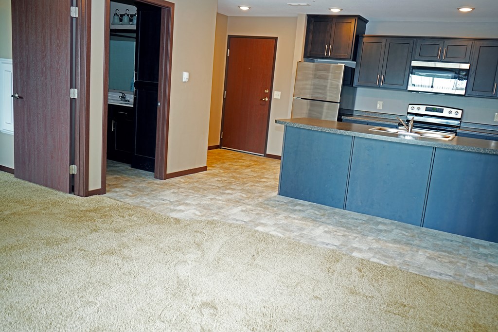 A kitchen with a blue counter and a brown door.