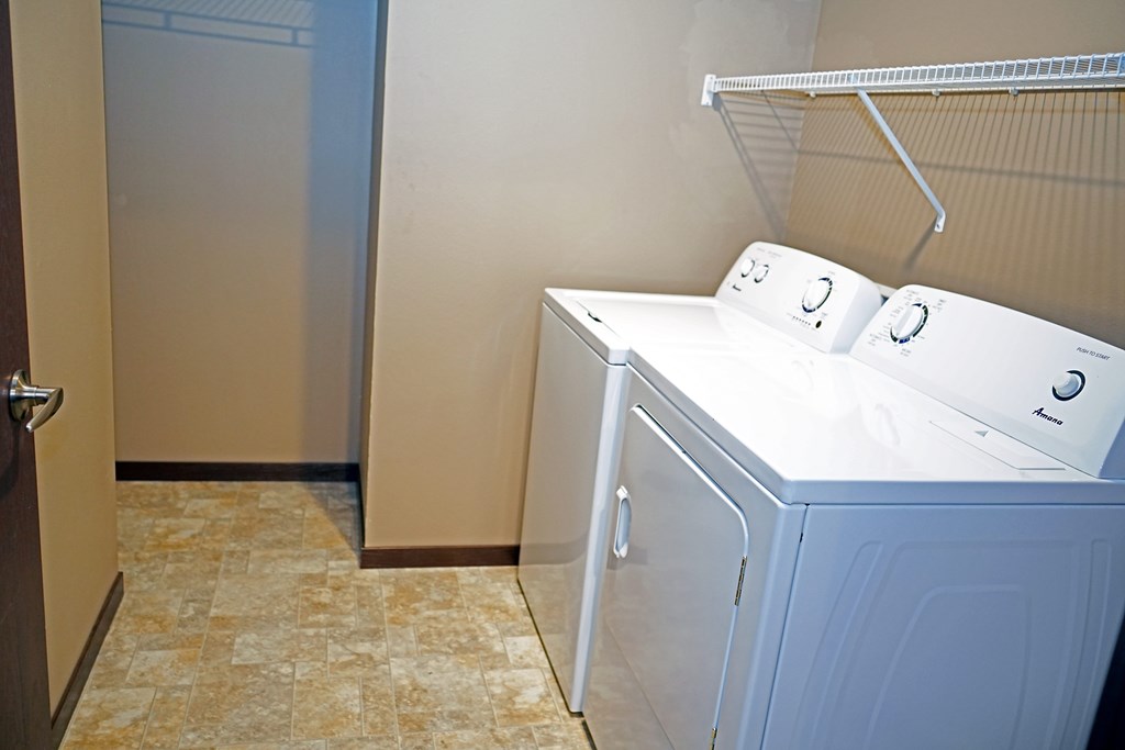 A white washing machine and dryer in a small laundry room.