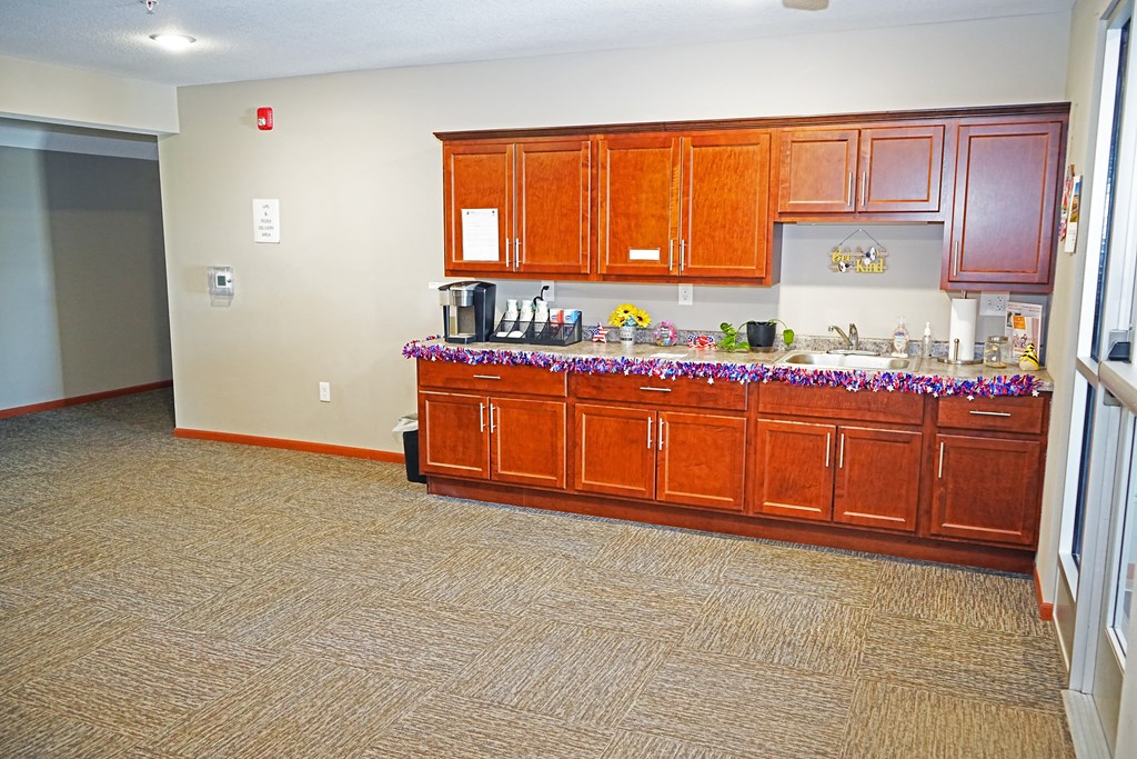 A kitchen with brown cabinets and a countertop with a floral arrangement.