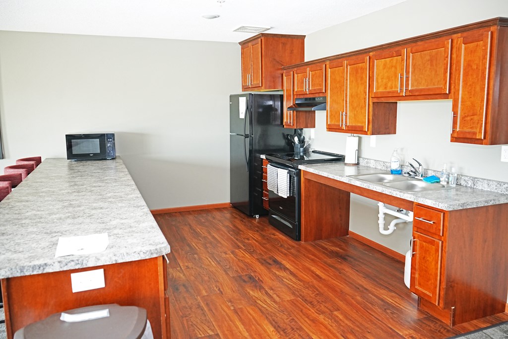 A kitchen with wooden cabinets and a granite counter top.