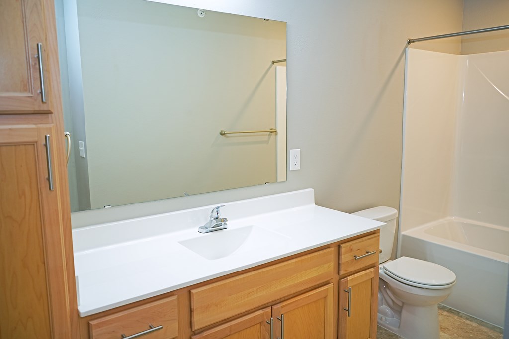 A bathroom with a sink, toilet, and bathtub.