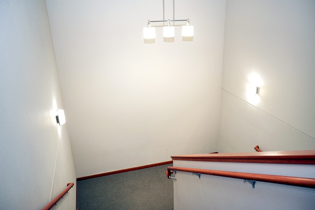 A white room with a light fixture and a red ledge.