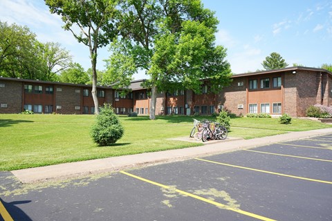 A parking lot in front of a building with a bicycle parked.