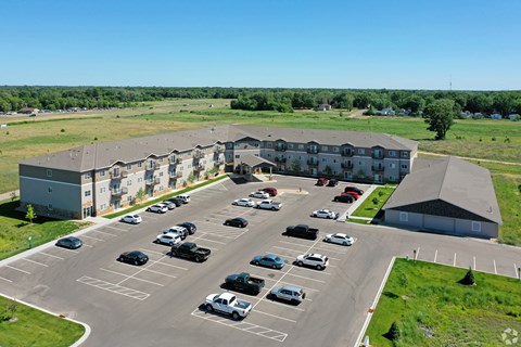 A parking lot with cars and a building in the background.