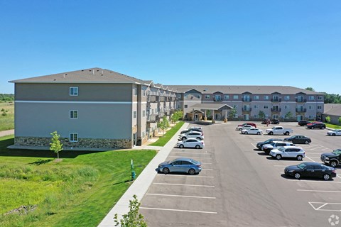 A parking lot with cars and a building in the background.