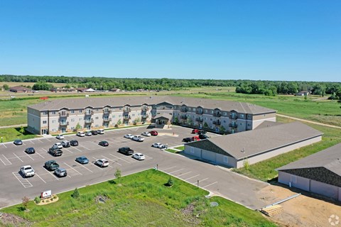 A parking lot with cars and a building in the background.
