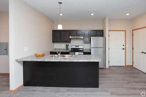 A kitchen with a black countertop and stainless steel appliances.