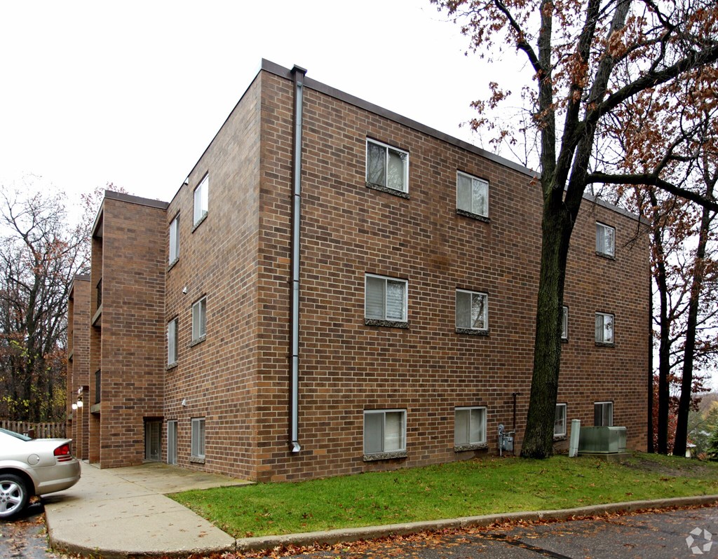 A brick building with a car parked in front.