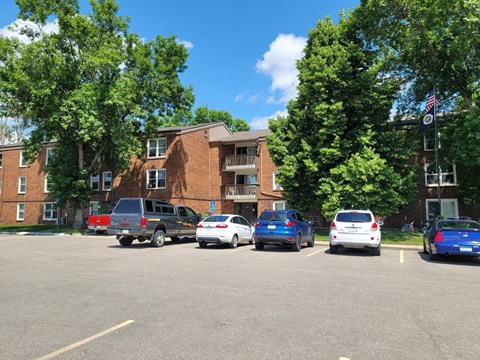 A parking lot with cars and a building in the background.