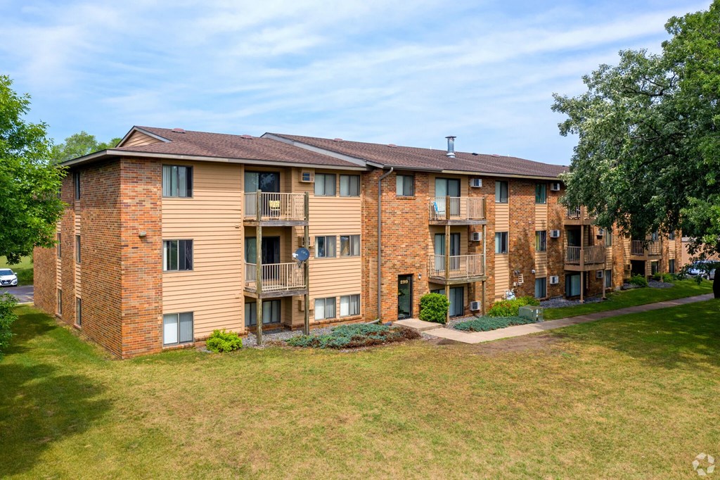 A large apartment complex with a grassy front yard.