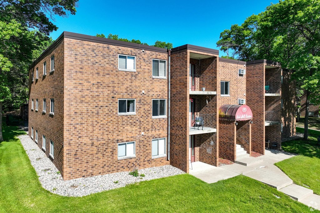 A red brick building with a green lawn in front.