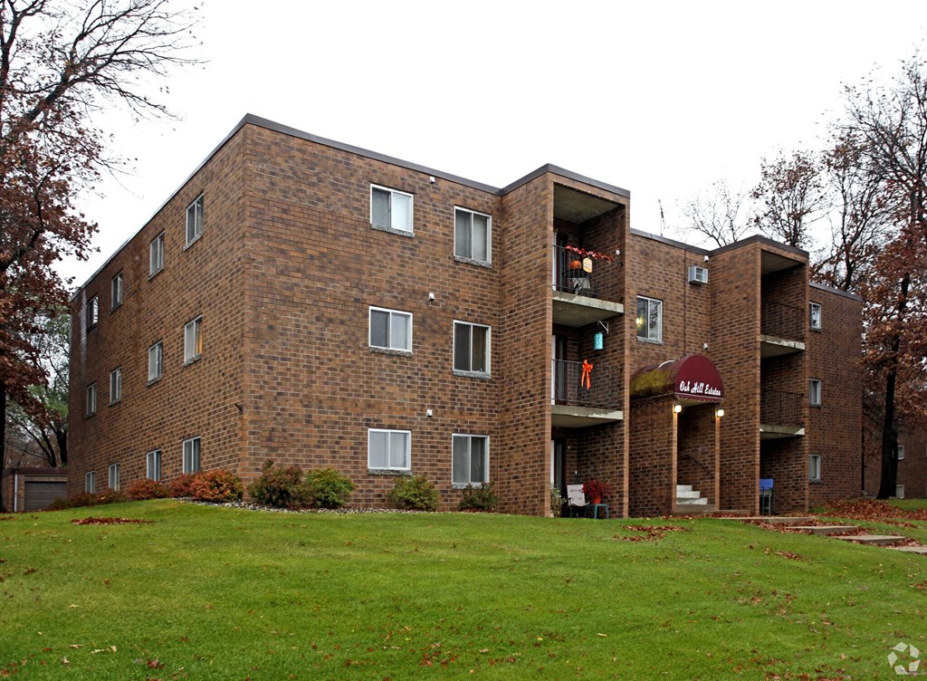 A brick apartment building with a green lawn in front.